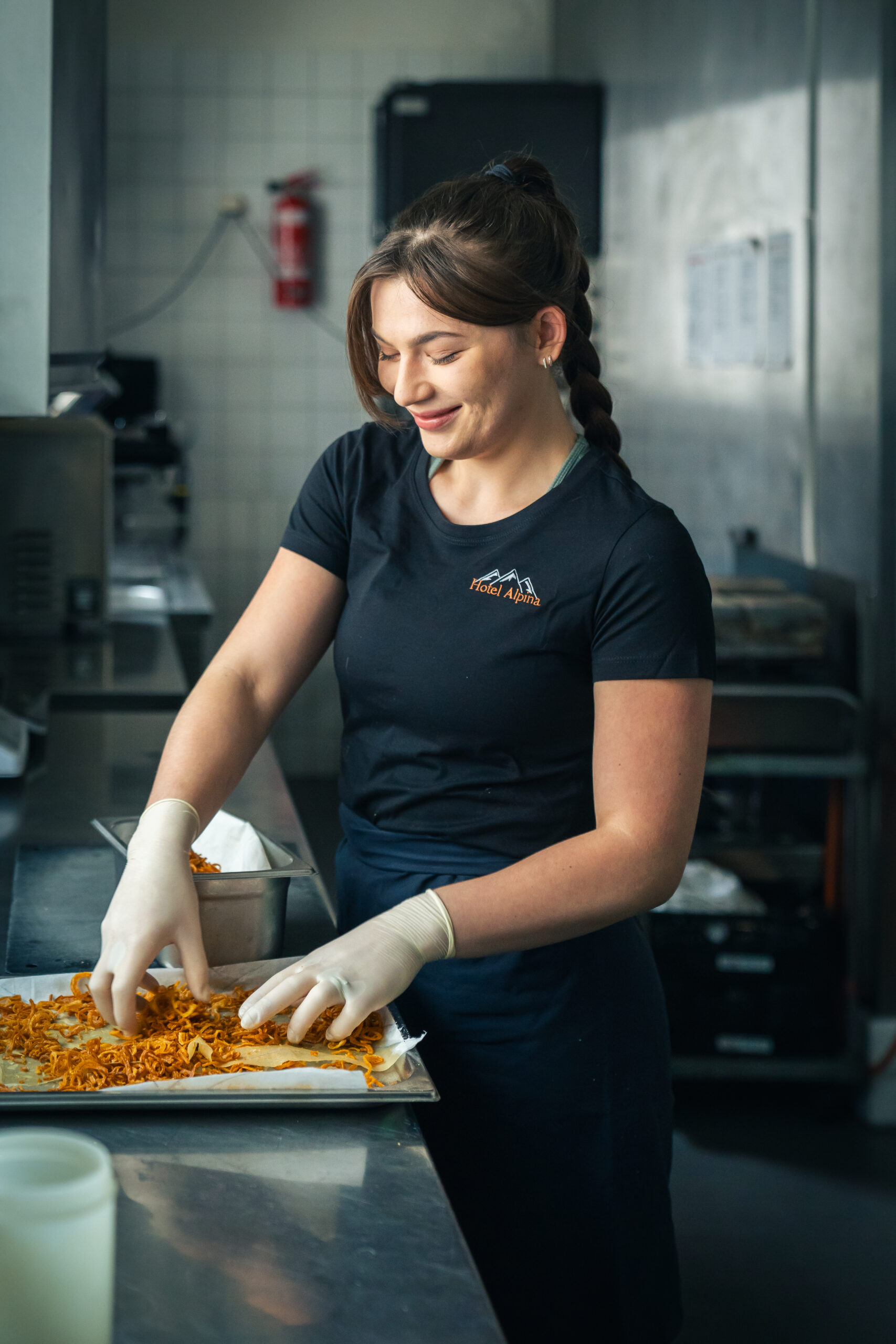 Jaroslava, kitchen assistant, preparing crispy fried onions in the restaurant kitchen