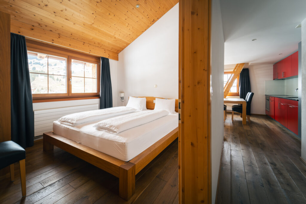Double bed with a view of the kitchen in the holiday apartment