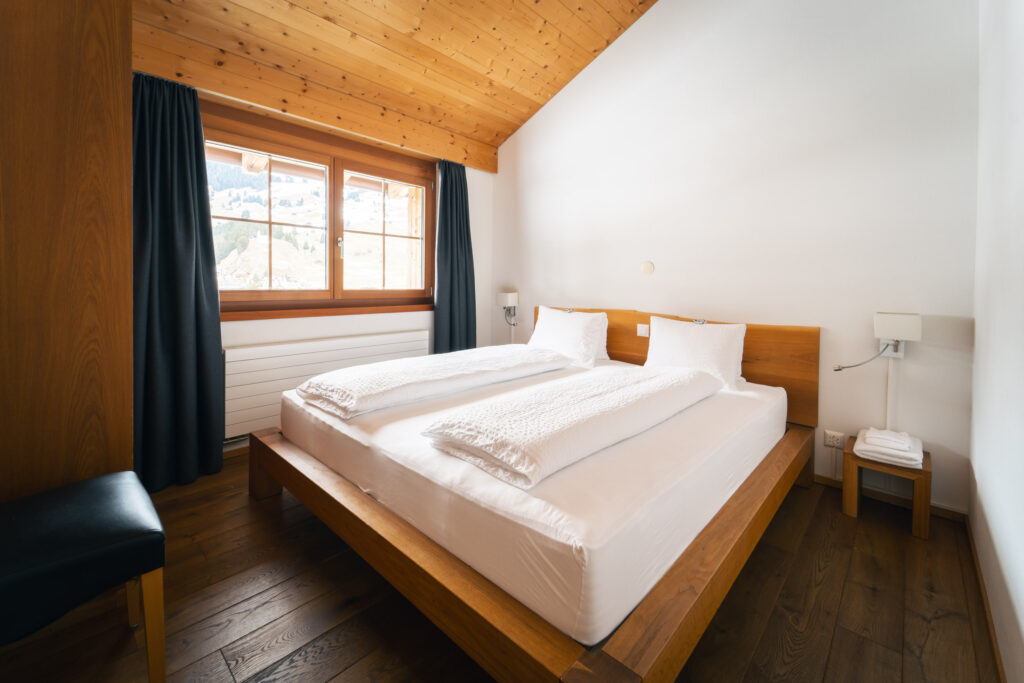 Bedroom with double bed in the holiday apartment at Alpina Brigels