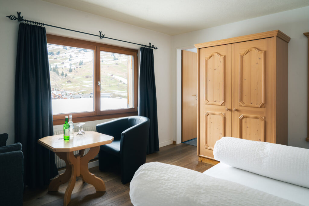 Double room with wooden wardrobe, desk, and access to the bathroom