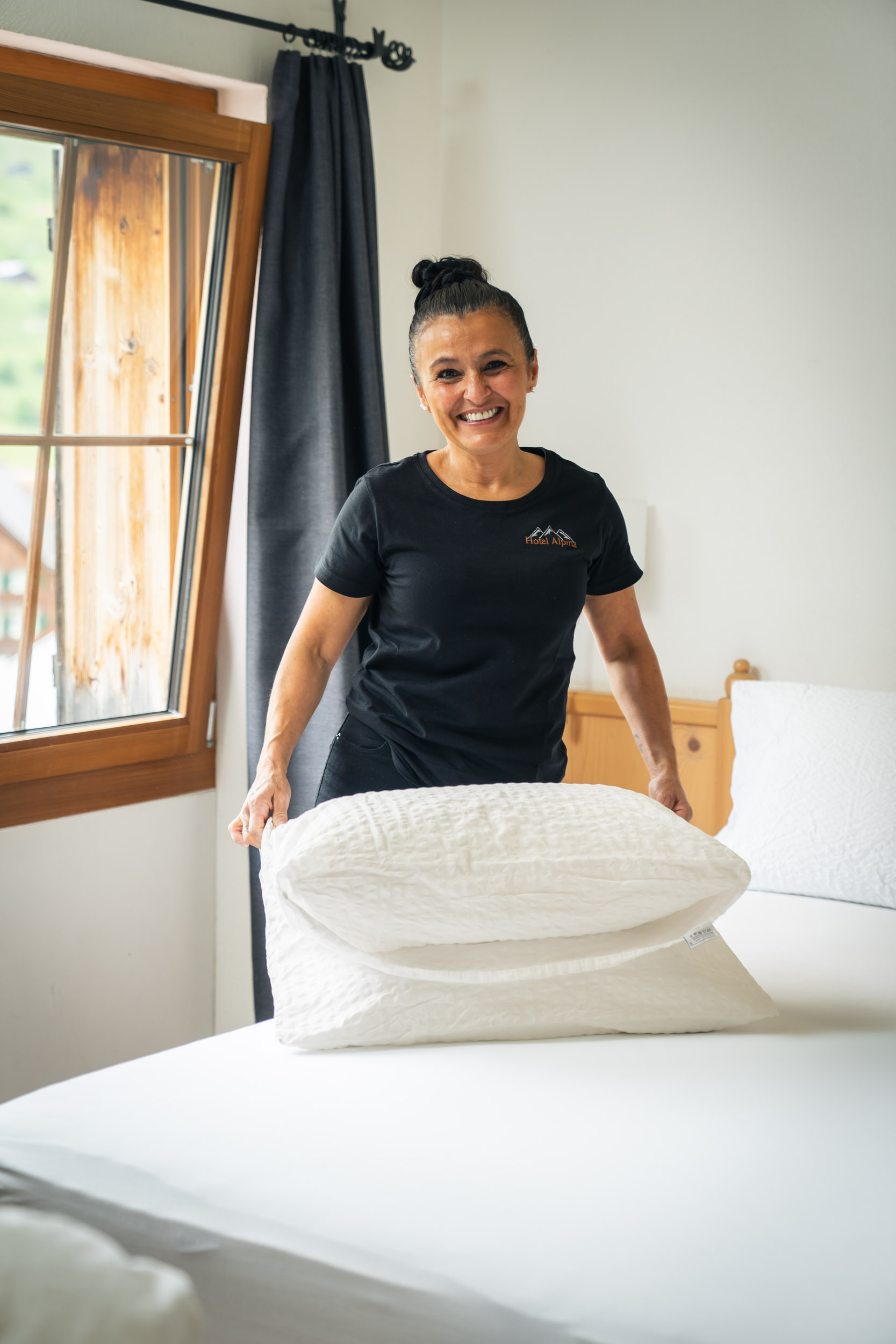 Anna from housekeeping arranging the pillows in the hotel room