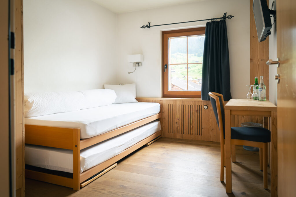 Unser Einzelzimmer mit Einzelbett Schreibtisch und TV mit Parkettboden