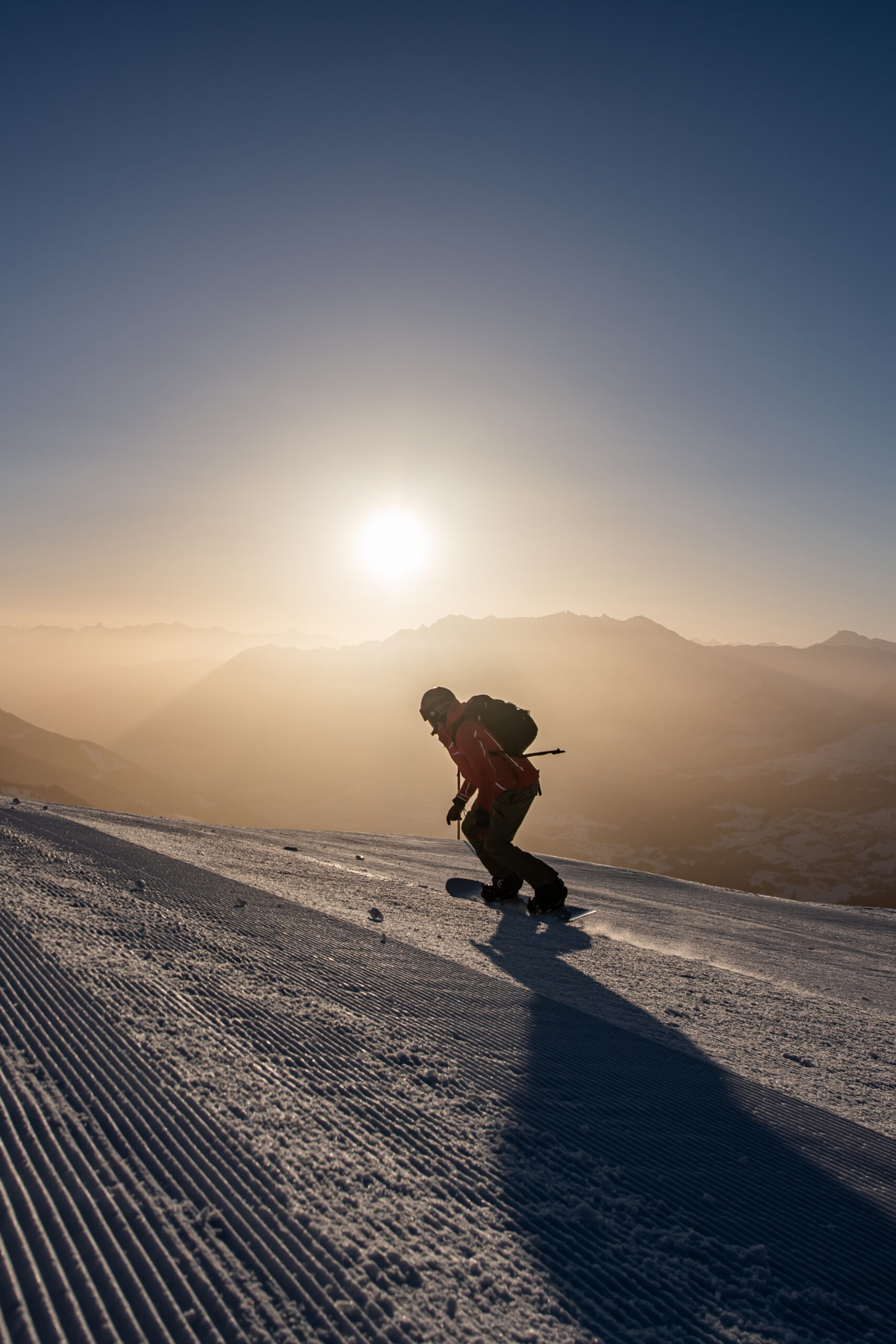 Snowboarder at sunrise on the beautiful slopes in Brigels