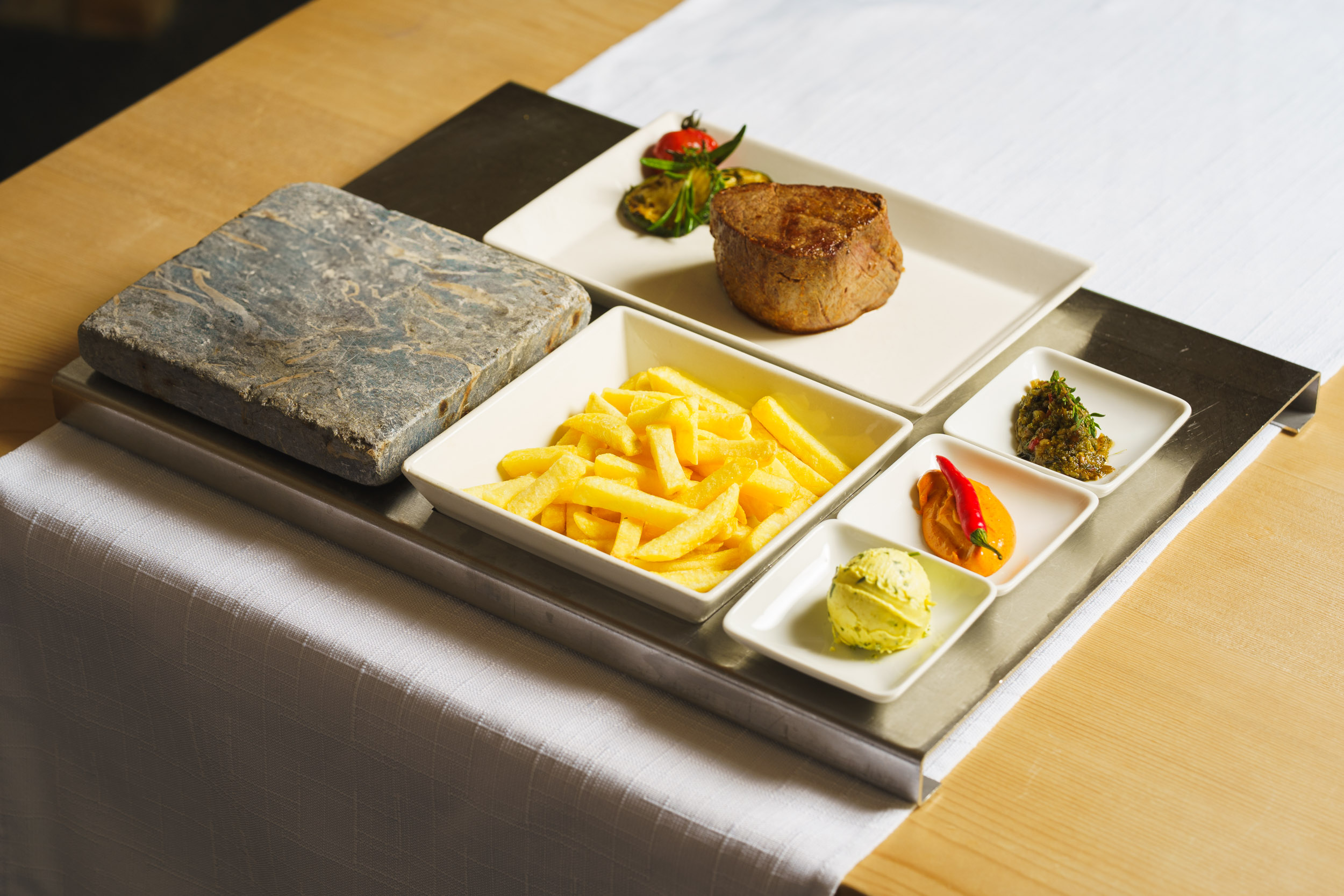 Dish: Hot stone specialty with beef fillet, served with French fries and various sauces – Brigels