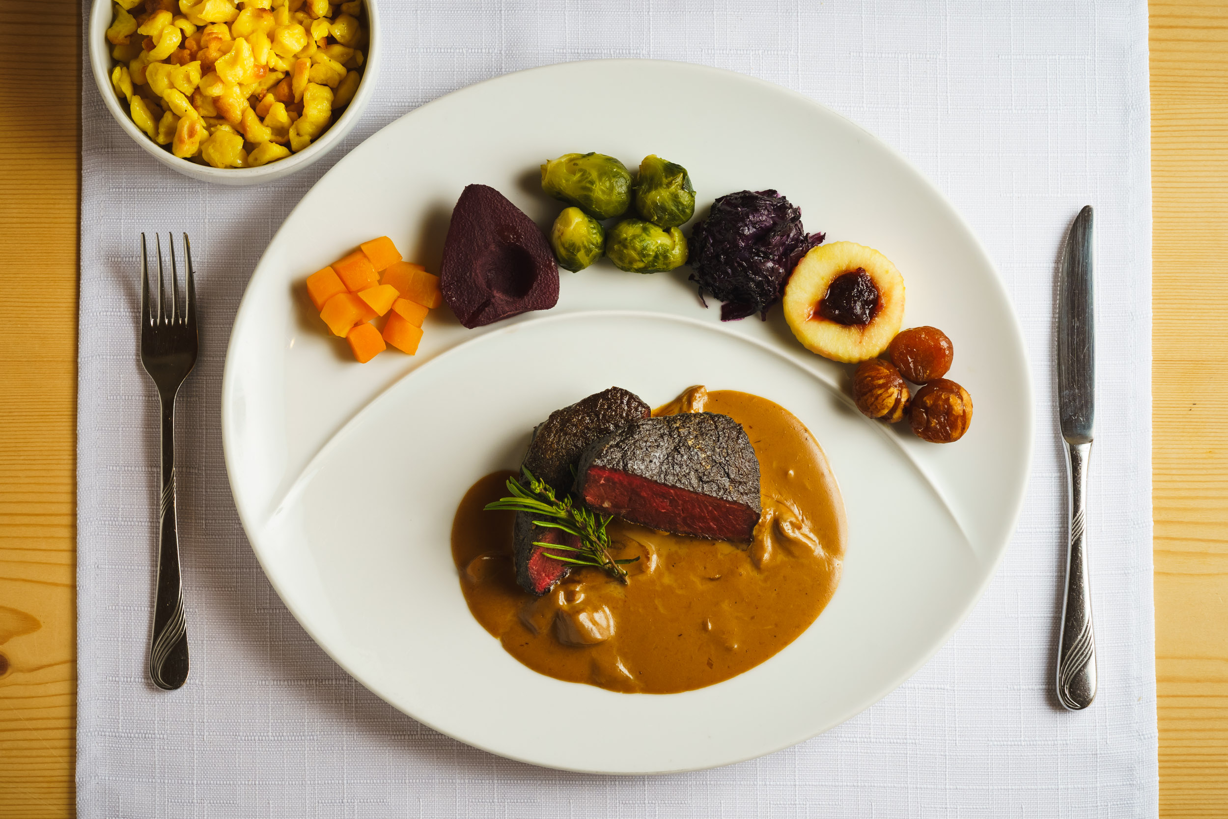 Restaurant dish: Venison entrecôte with porcini cream sauce, served with vegetables from our own garden and homemade spaetzle